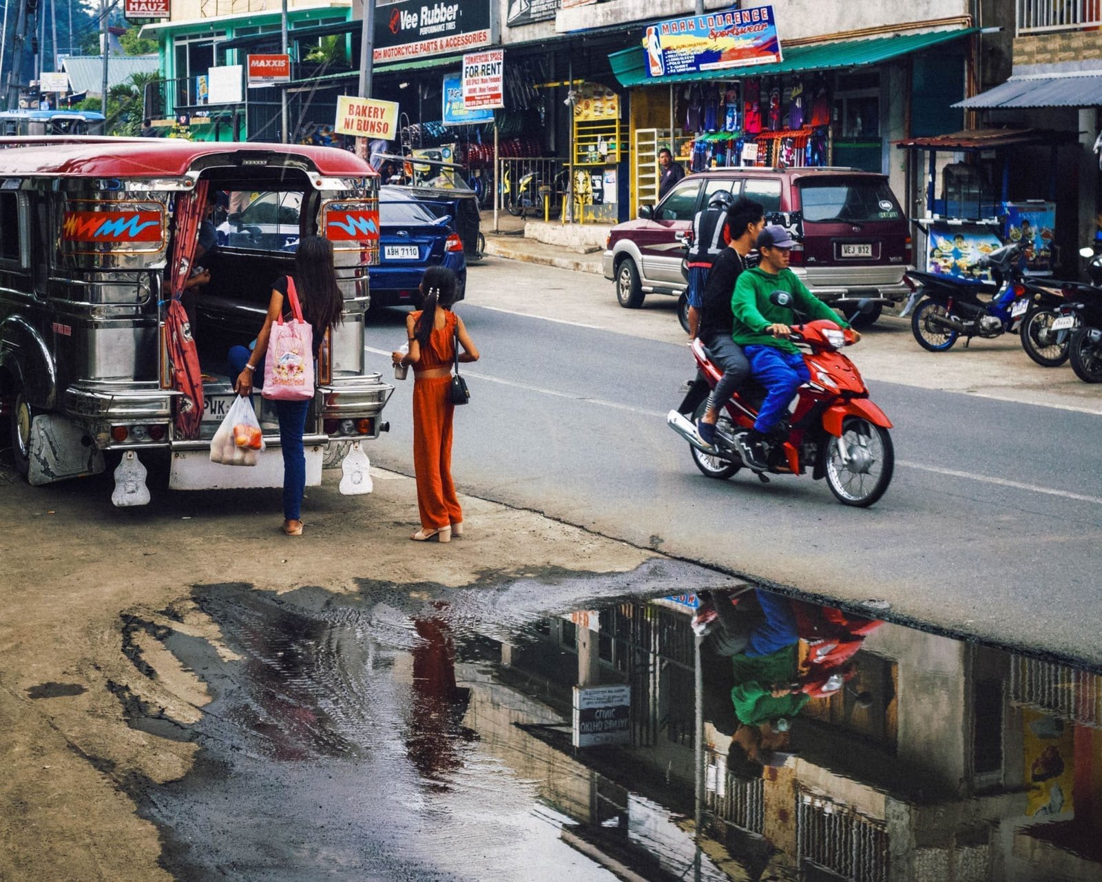 Tagaytay street with vibrant jeepney, motorcycle, and bustling local life.