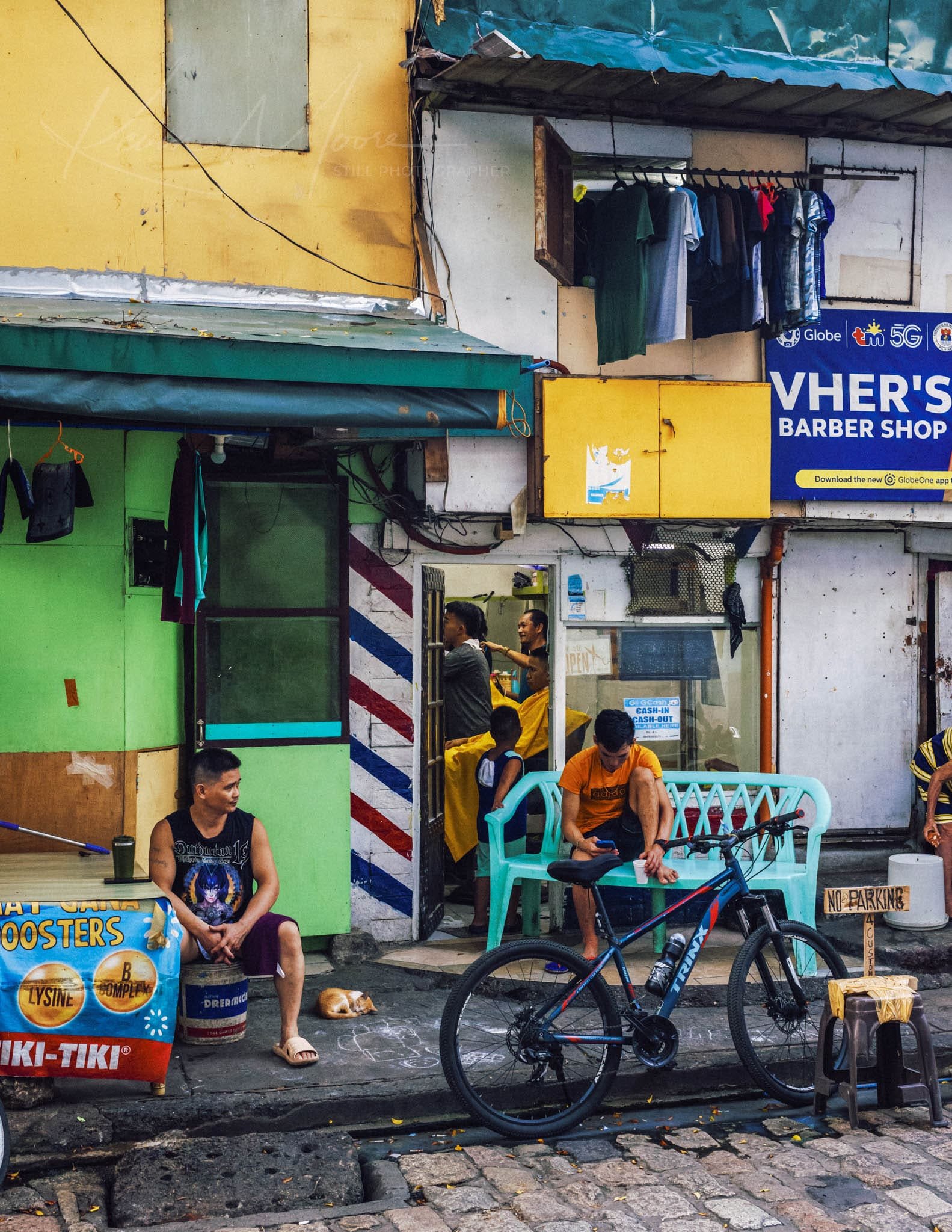 Vibrant urban street scene with a bustling barbershop and colorful architecture.