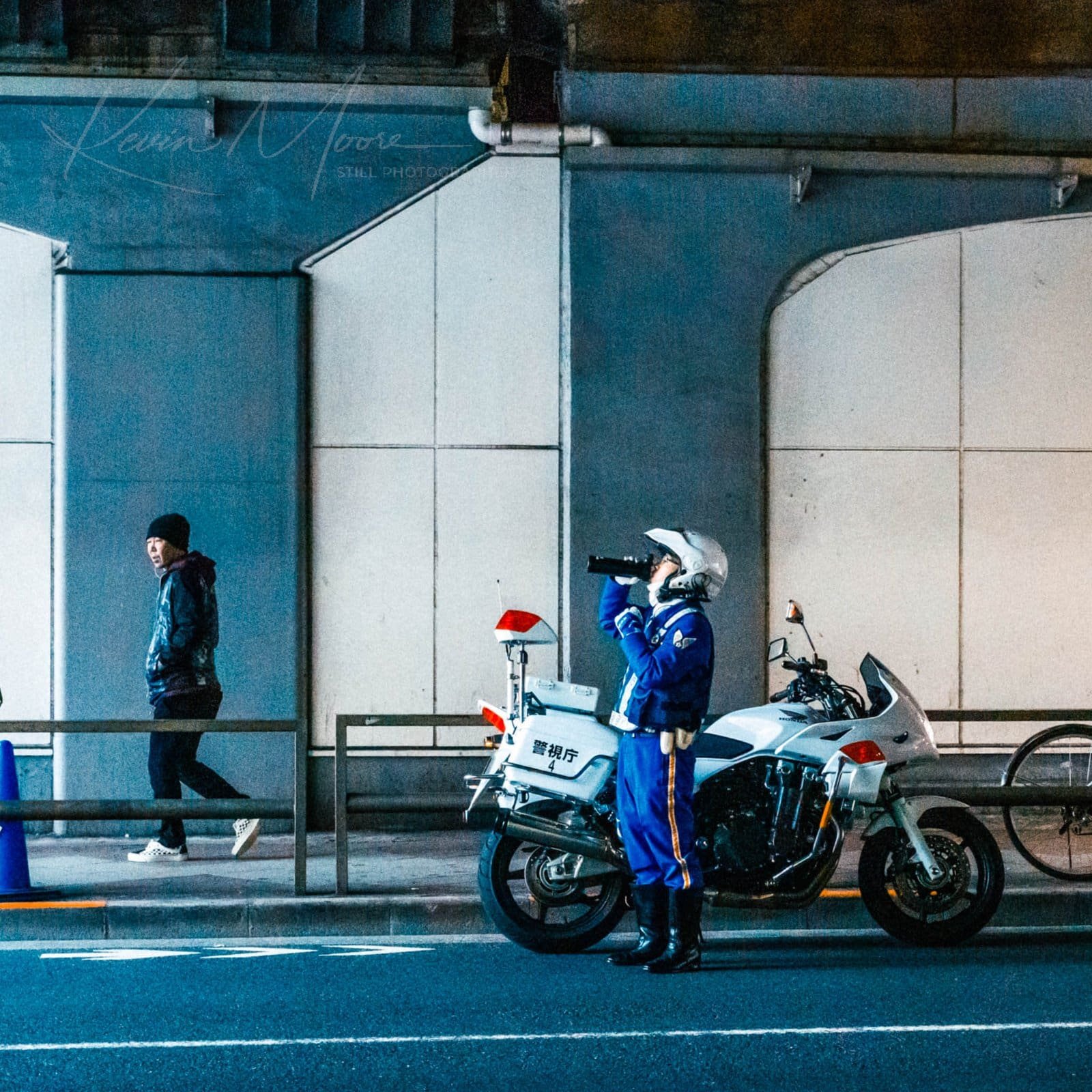 Tokyo Street Photography of Police officer in Japan using radar gun under an overpass.